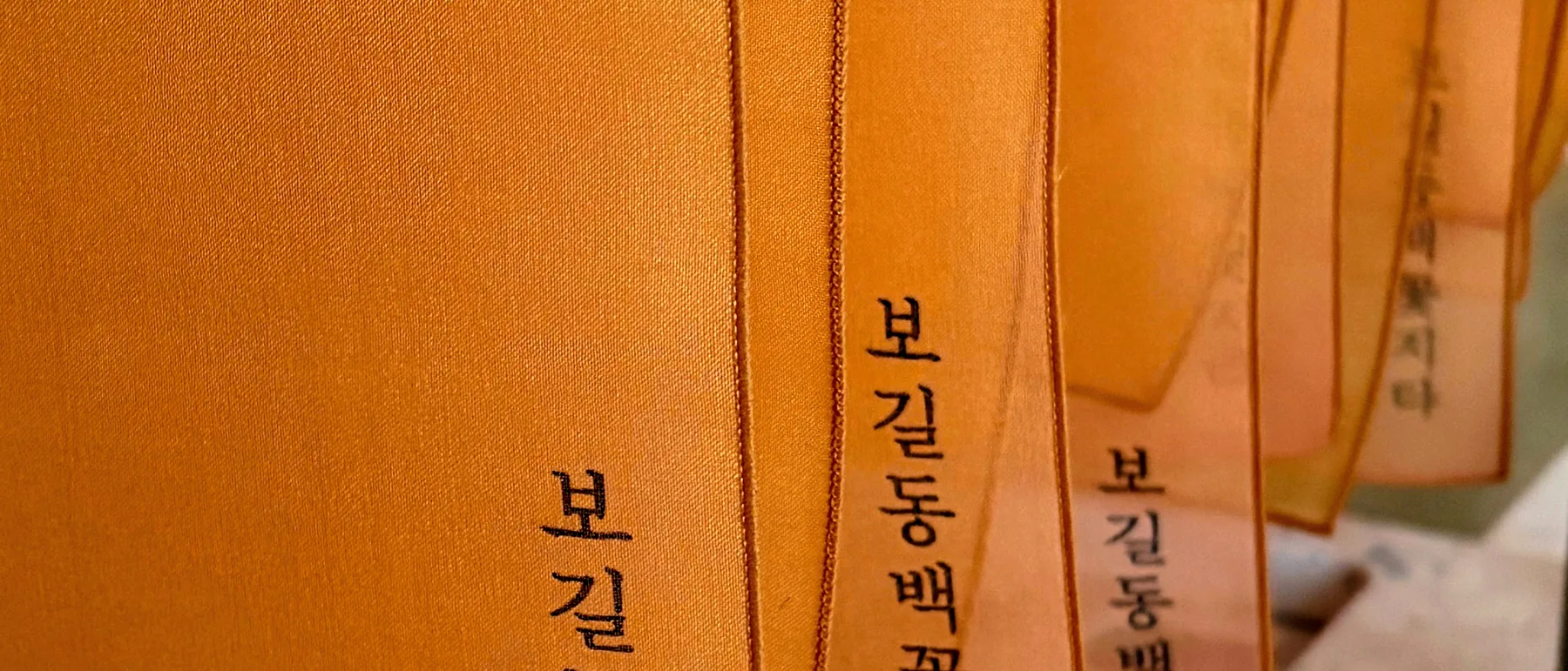 보길동백꽃지다 라고 적힌 주황 보자기들이 나란히 걸려 있는 모습
